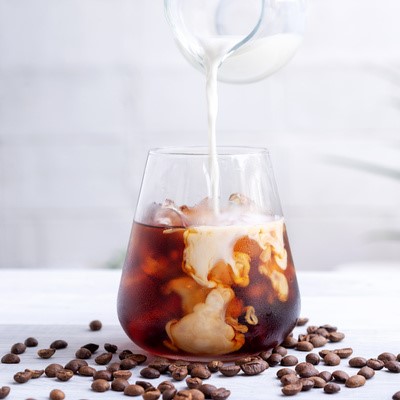 cold brew coffee with milk on white wooden table 